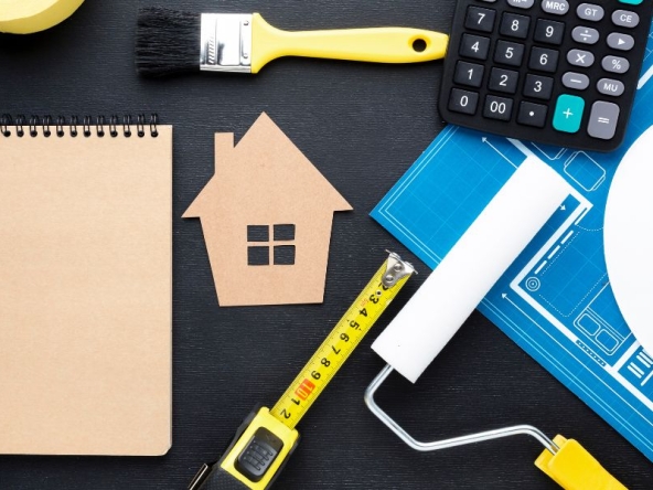 Strumenti per ristrutturazione e miglioramento dell'efficienza energetica, come metro e pennello da pittura, simbolizzano lavori di rinnovamento e manutenzione ordinaria degli edifici.