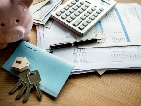 Documenti, salvadanaio e chiavi di casa: simboli della gestione delle spese condominiali, della ripartizione dei costi tra proprietari e inquilini e dell'amministrazione finanziaria del condominio.