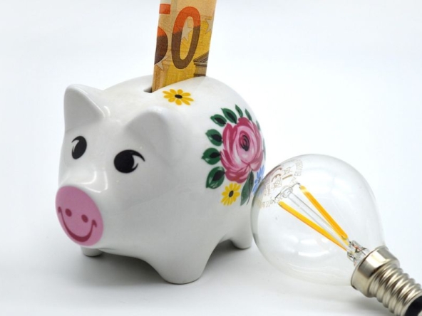 Immagine di salvadanaio e lampadina ad indicare il risparmio ottenuto dal bonus bollette e agevolazioni per le famiglie.