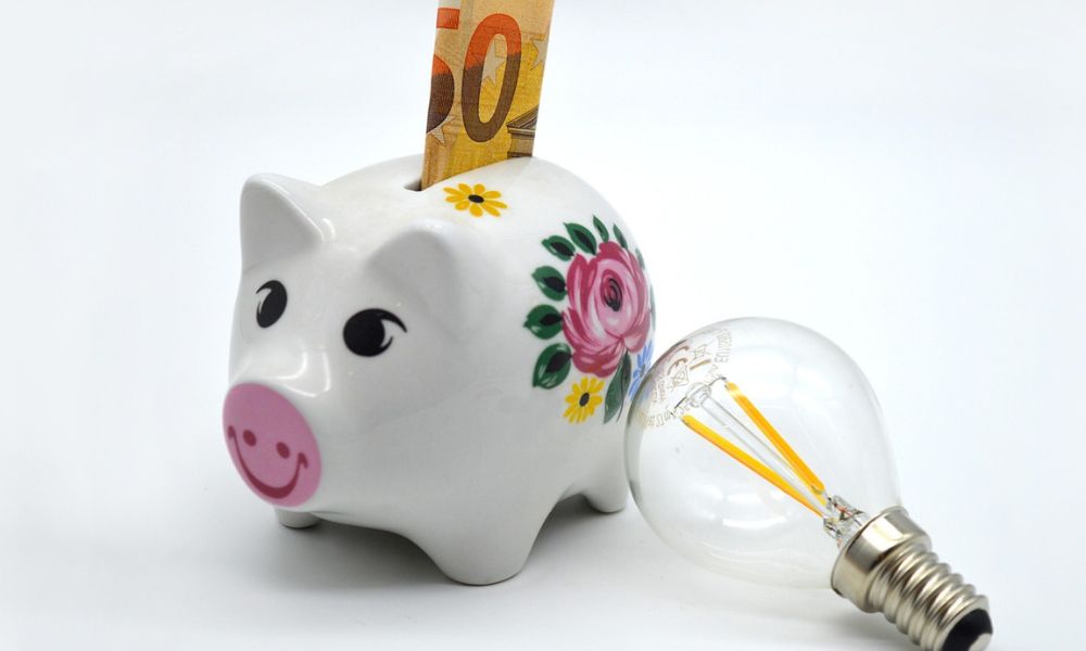 Immagine di salvadanaio e lampadina ad indicare il risparmio ottenuto dal bonus bollette e agevolazioni per le famiglie.