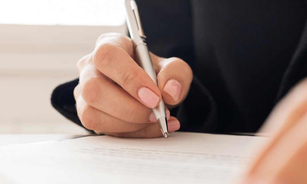 Persona che firma un compromesso immobiliare.