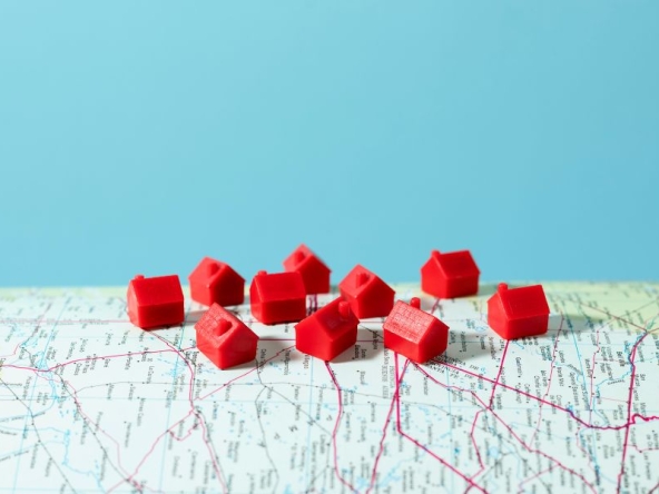 Case in miniatura su una mappa, ad indicare immobili a reddito lontano.