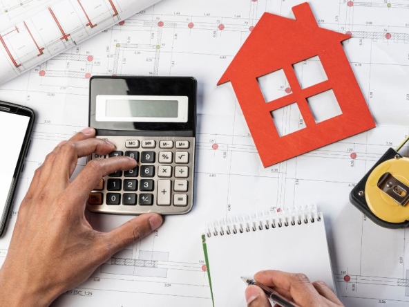 Persona che fa calcoli per la valutazione immobiliare in base a vari aspetti.