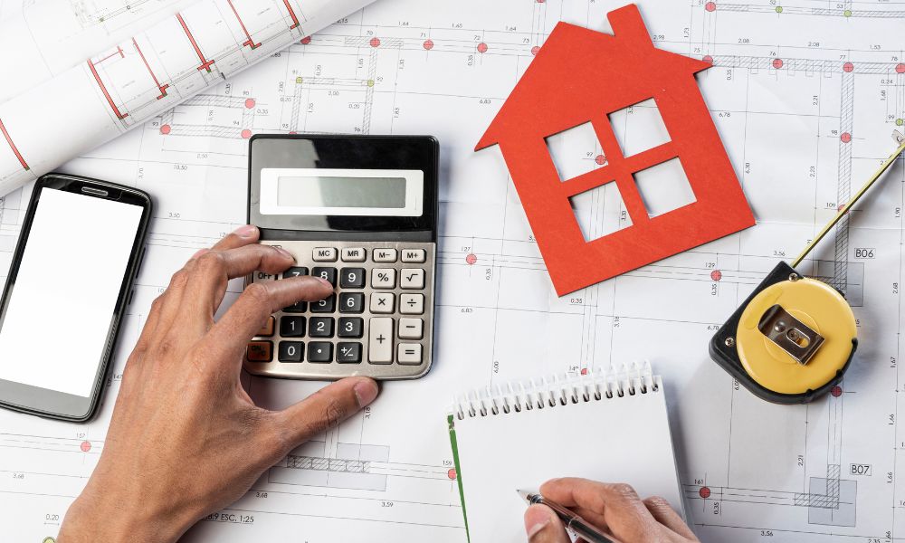 Persona che fa calcoli per la valutazione immobiliare in base a vari aspetti.
