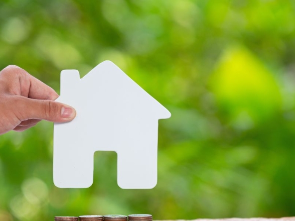 Mano che regge una sagoma di casa, per riprendere l'argomento prima casa: agevolazioni 2026