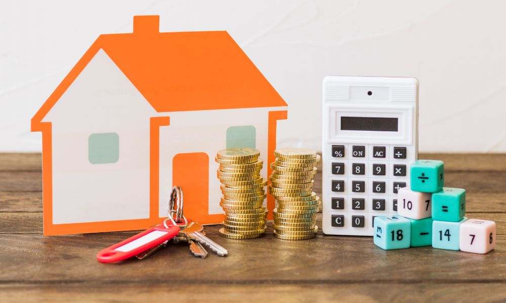 Calcolatrice, casa in miniatura, denaro. Tanti simboli che riportano al pagamento IMU