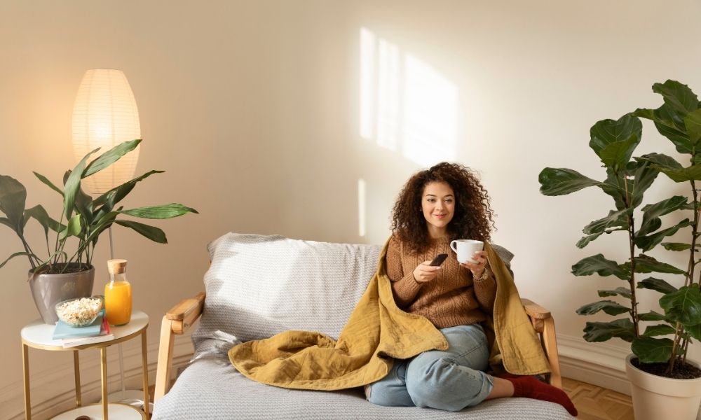 Donna che abita da sola sul suo divano che si rilassa