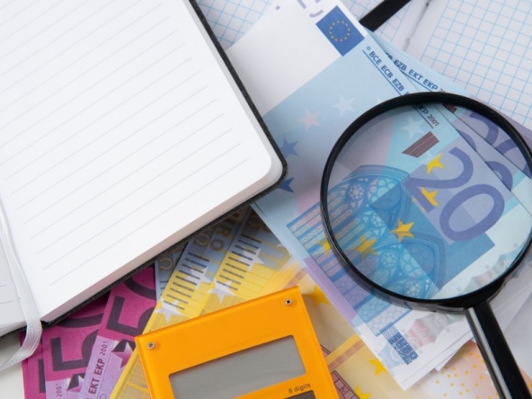 Immagini di calcolatrice, blocchetto, soldi e lente di ingrandimento, a simboleggiare le politiche fiscali