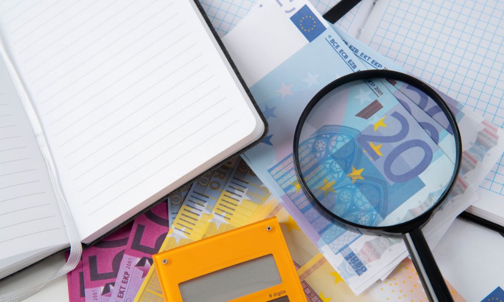 Immagini di calcolatrice, blocchetto, soldi e lente di ingrandimento, a simboleggiare le politiche fiscali