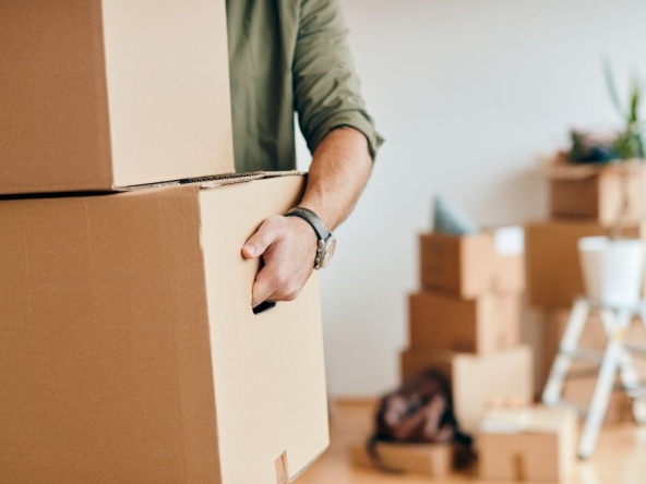 Uomo che trasporta dei pacchi, mentre organizza un trasloco