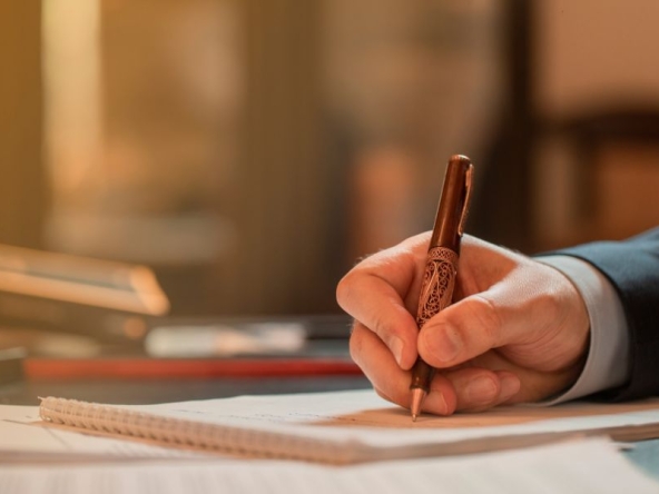 Uomo elegante che firma documenti importanti, come certificati catastali